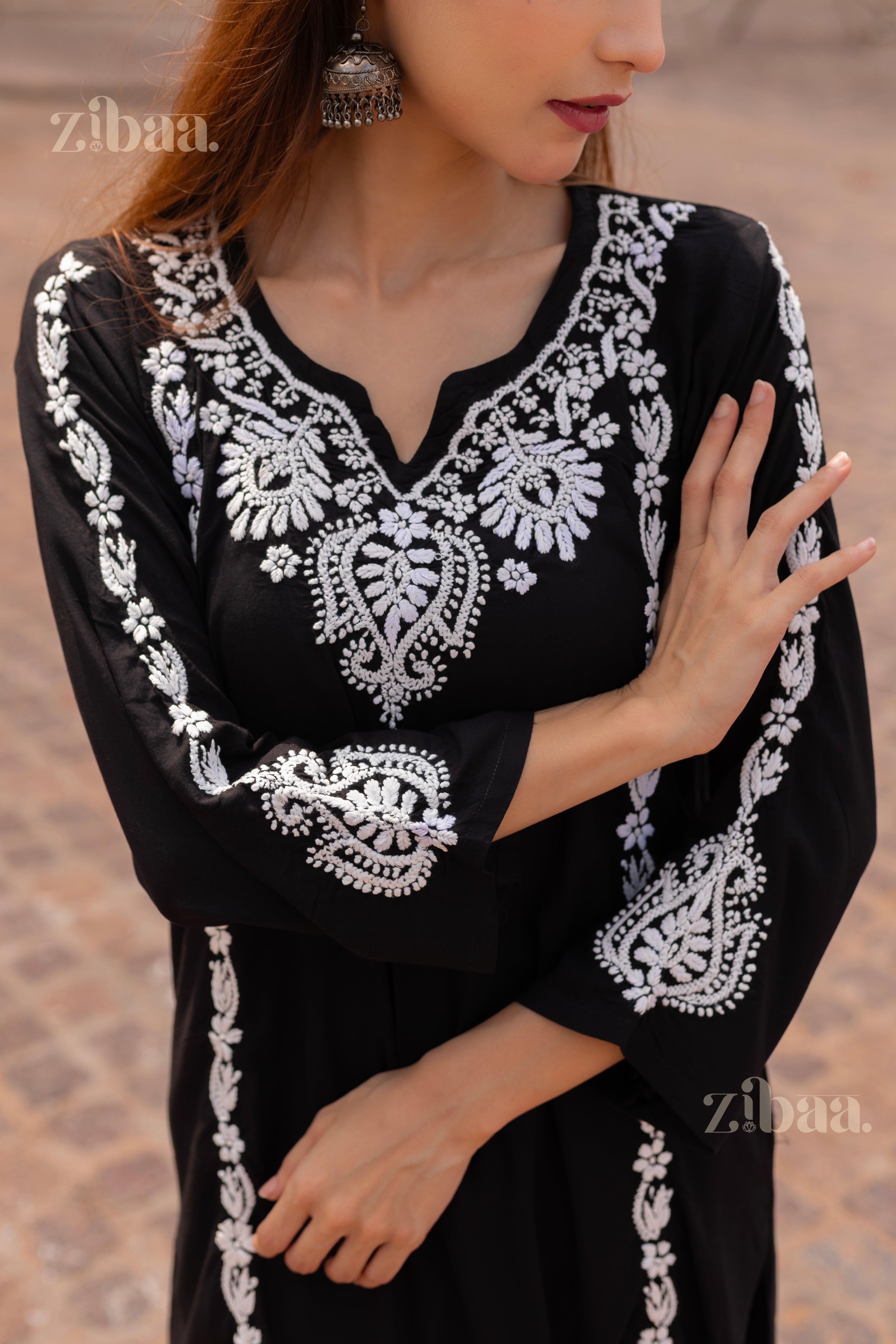 Close-up of a Black Chikankari Kurti featuring intricate white embroidery on the neckline and sleeves, styled with statement earrings