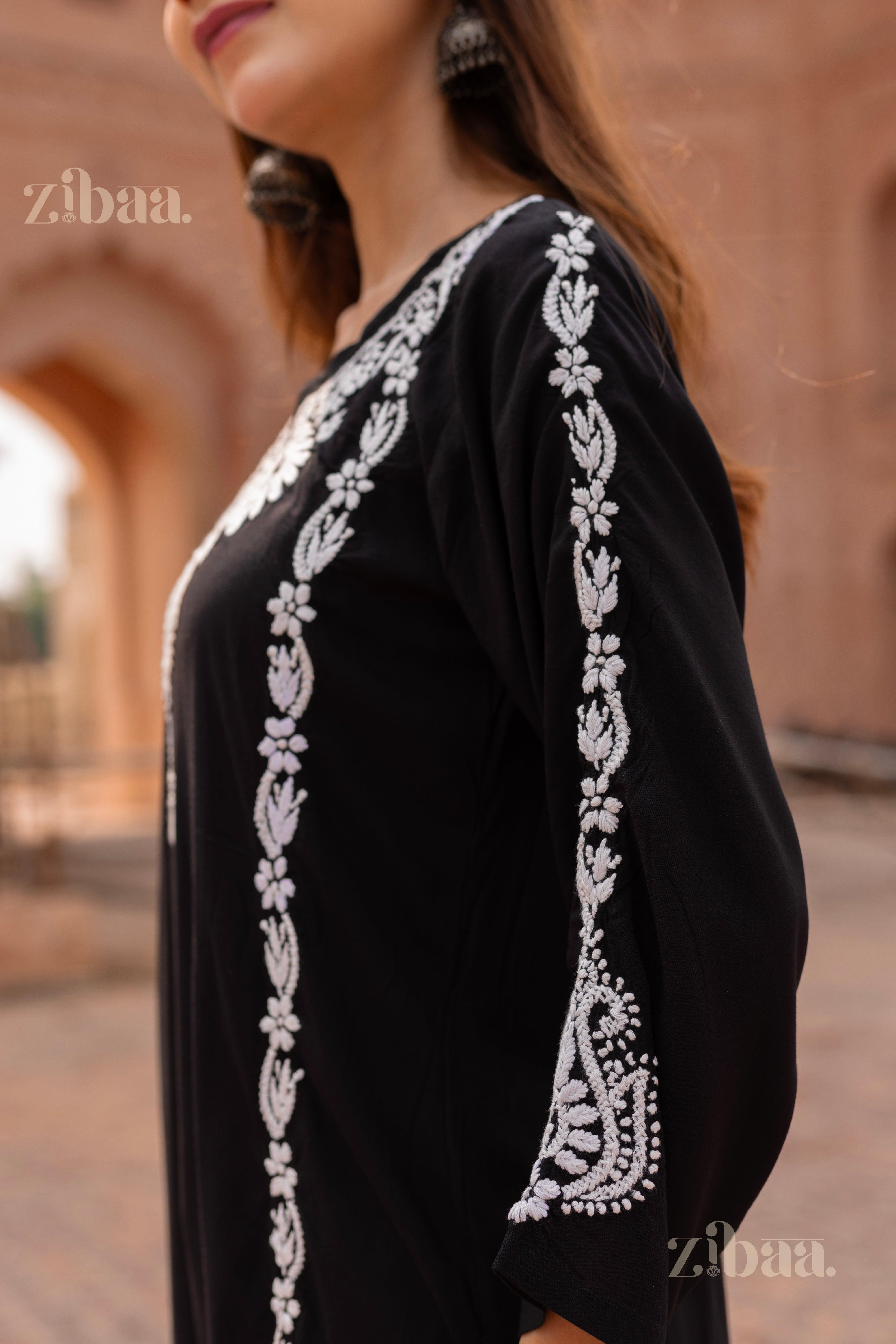 Side view of a Black Kurti featuring intricate white embroidery on the sleeves and sides, styled gracefully in a heritage setting