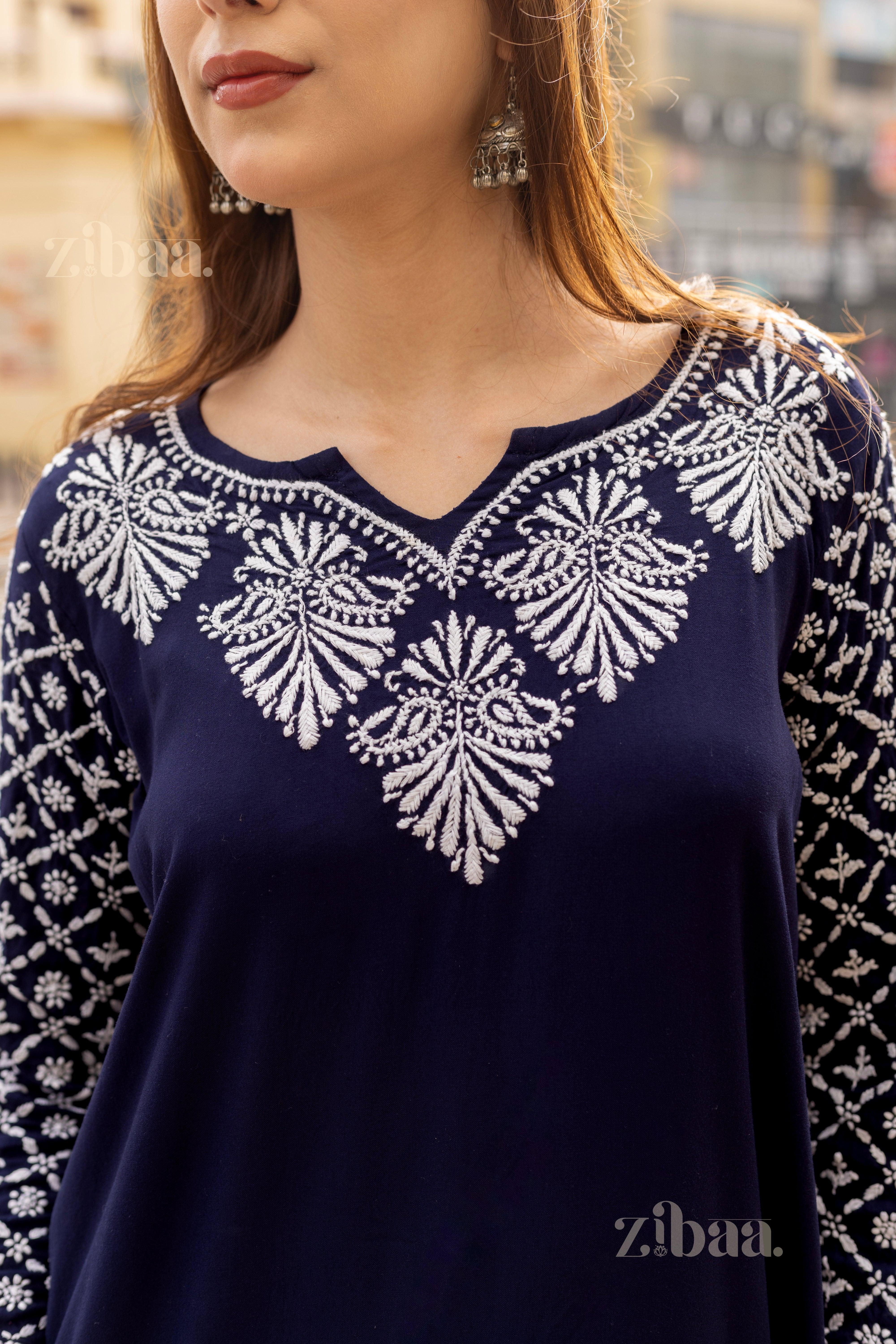 Close-up of a Blue Chikankari Kurti featuring intricate white embroidery on the neckline and sleeves, styled with statement earrings.