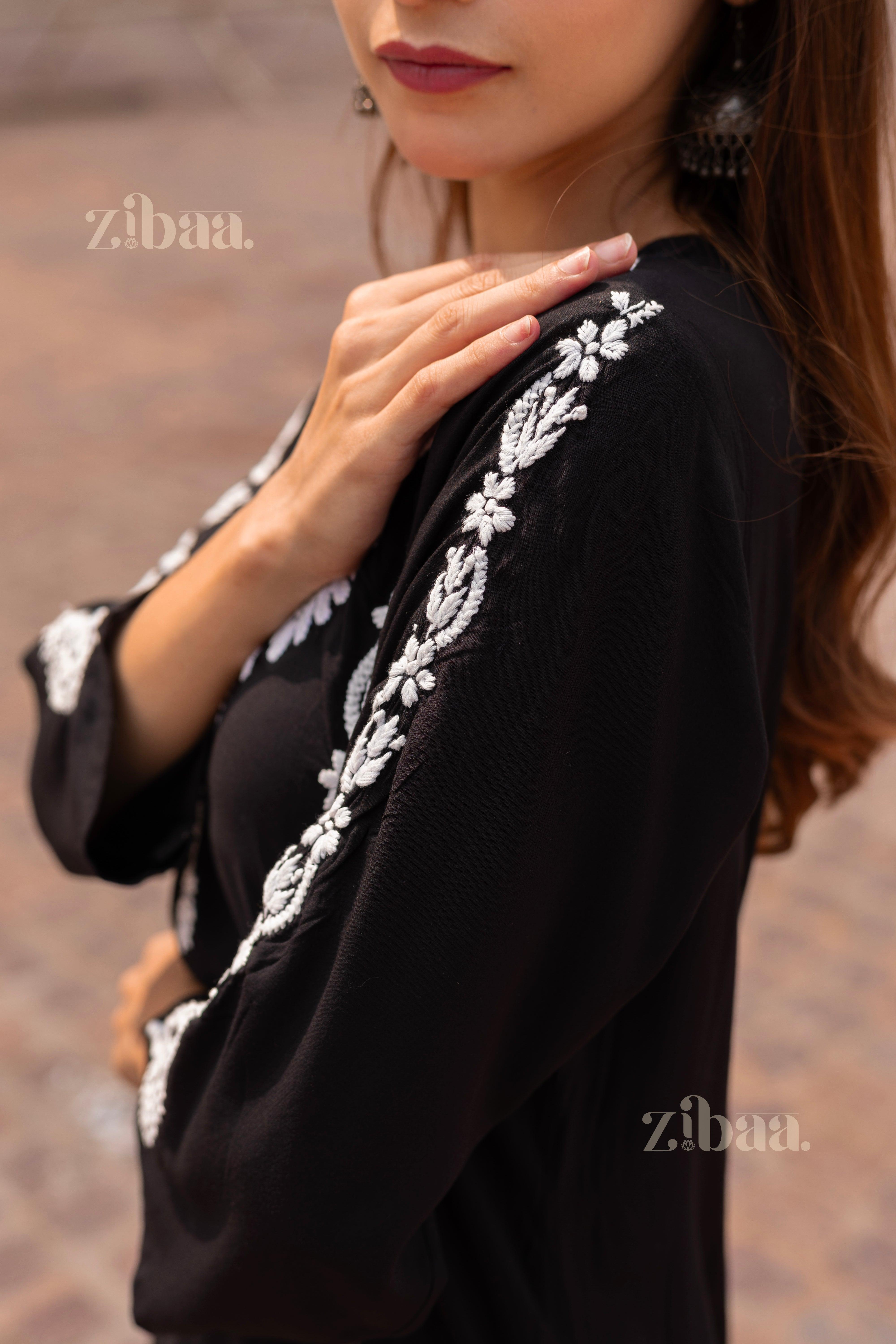 Side view of a Black Kurti showcasing intricate white embroidery on the sleeves, styled elegantly with bold earrings for a refined look