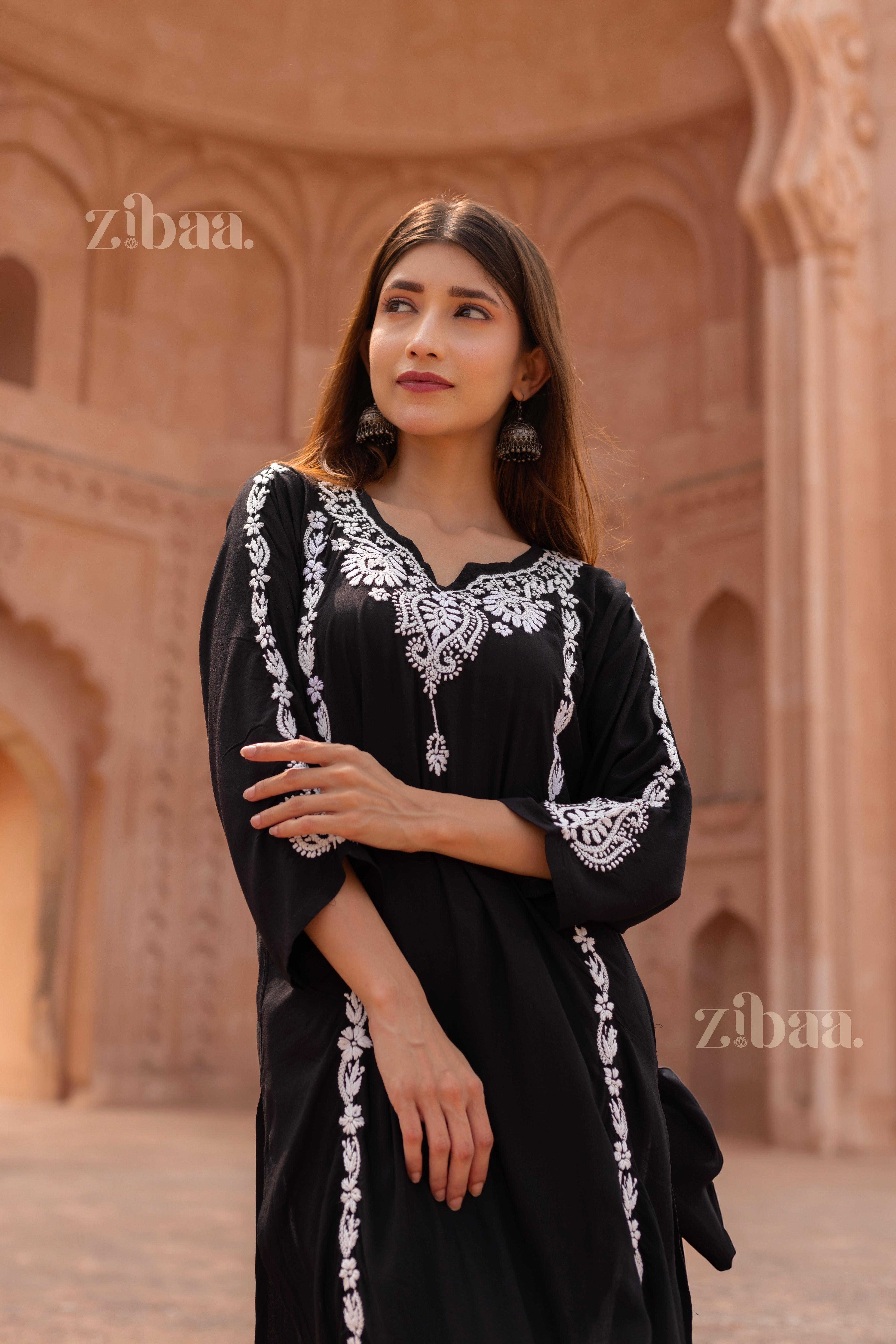 Model wearing a Black Chikankari Kurti with intricate white embroidery, posing gracefully in front of a stunning heritage architectural backdrop