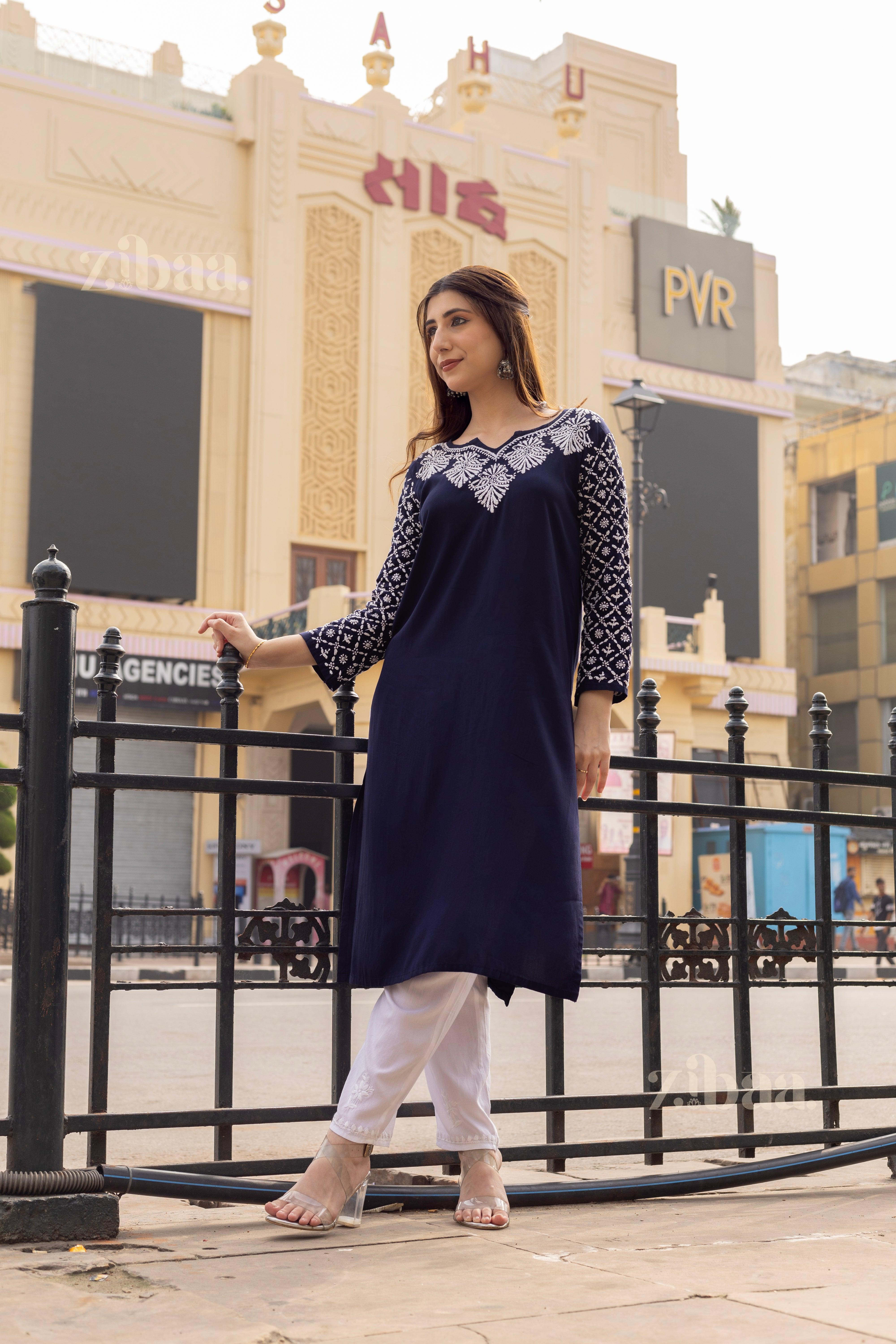 Model wearing a Navy Blue Chikan Kurta with white embroidery, paired with white pants, posing gracefully in an urban outdoor backdrop.