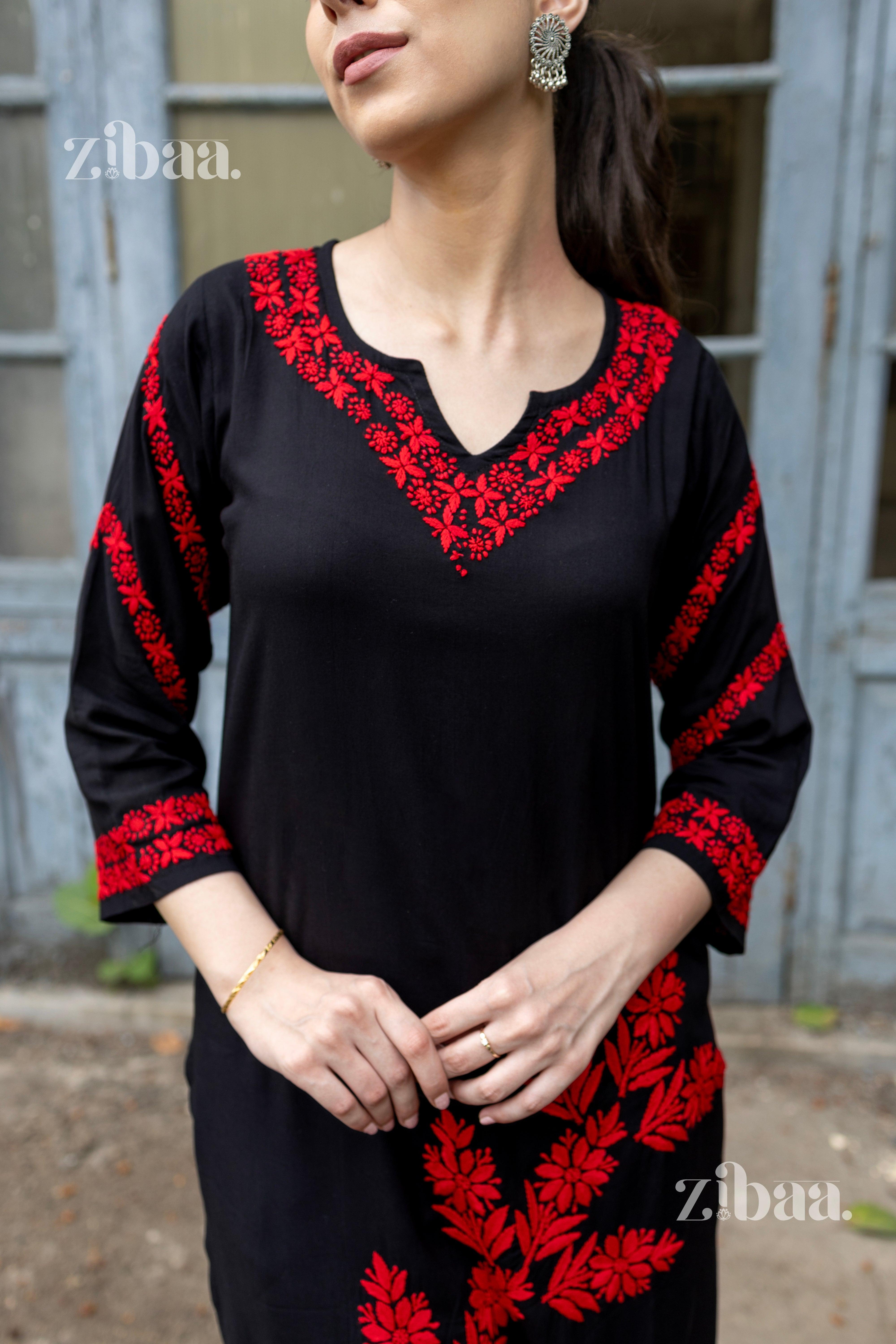 Close-up of a black kurti for women featuring vibrant red floral embroidery on the neckline, sleeves, and hem, styled with earrings.