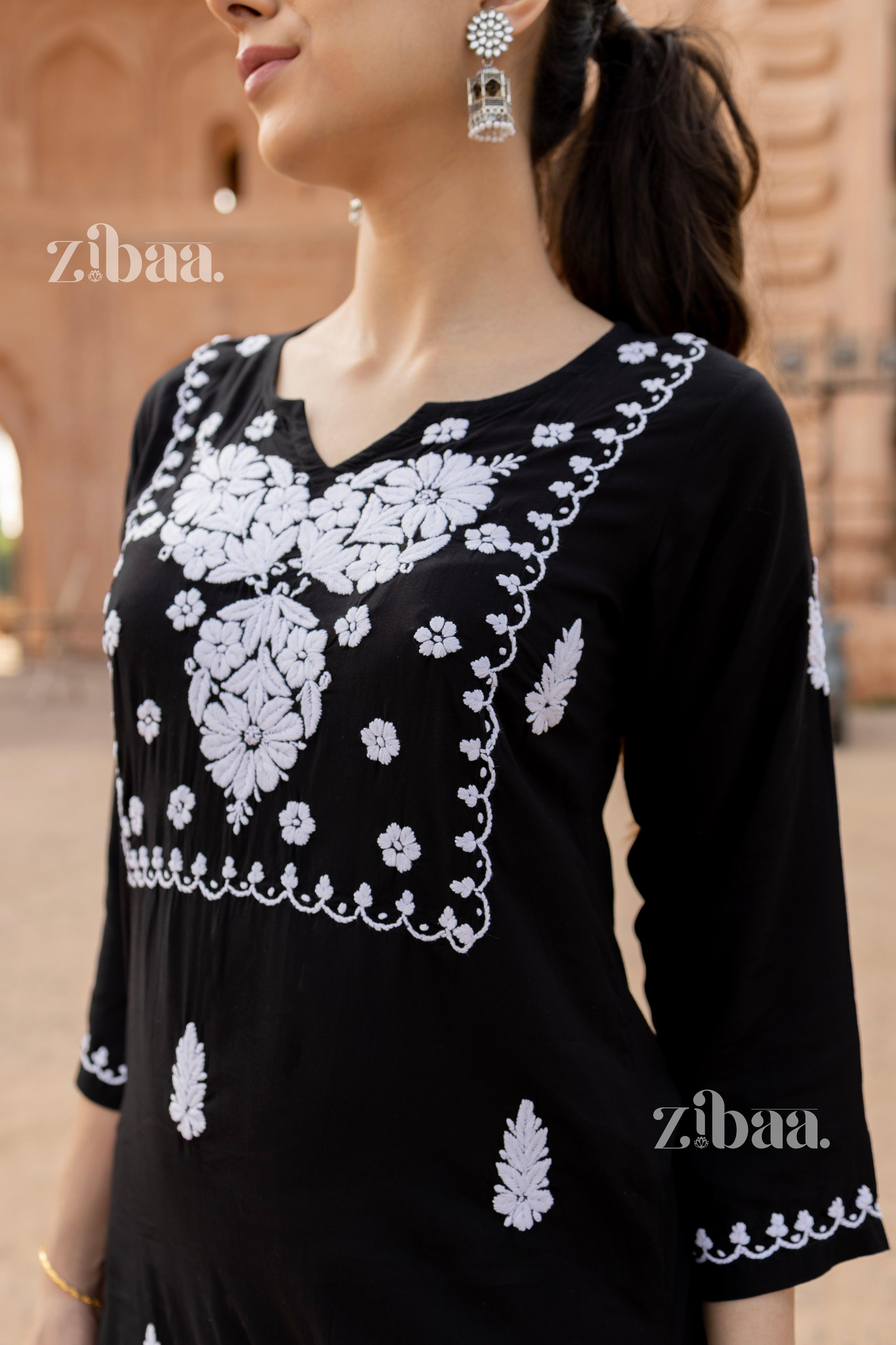 Close-up of a black and white kurti featuring elegant floral Chikankari embroidery, styled with statement earrings for a timeless look.