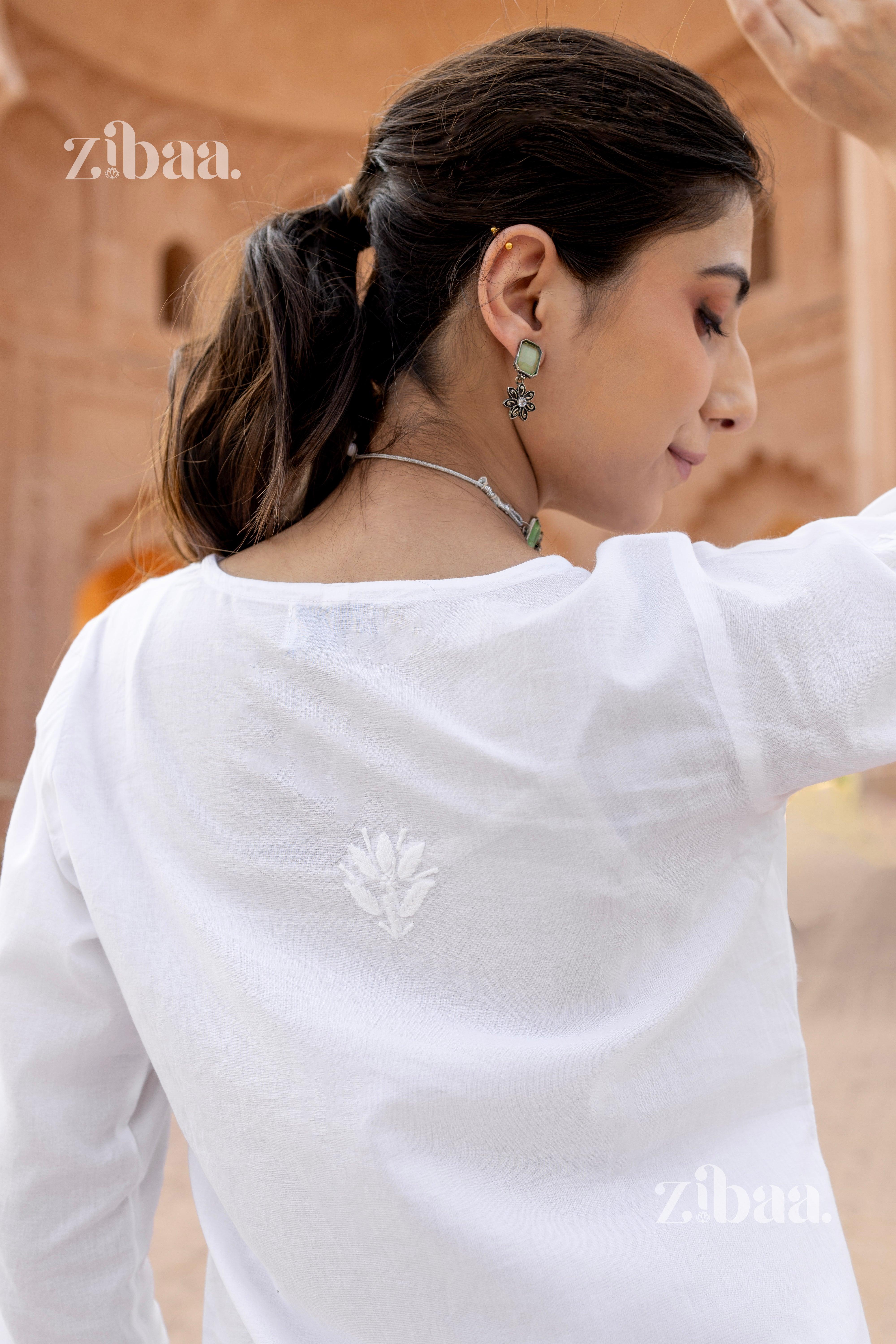 Back view of a woman in a white chikan kurti featuring subtle floral embroidery, styled with a ponytail and elegant earrings.