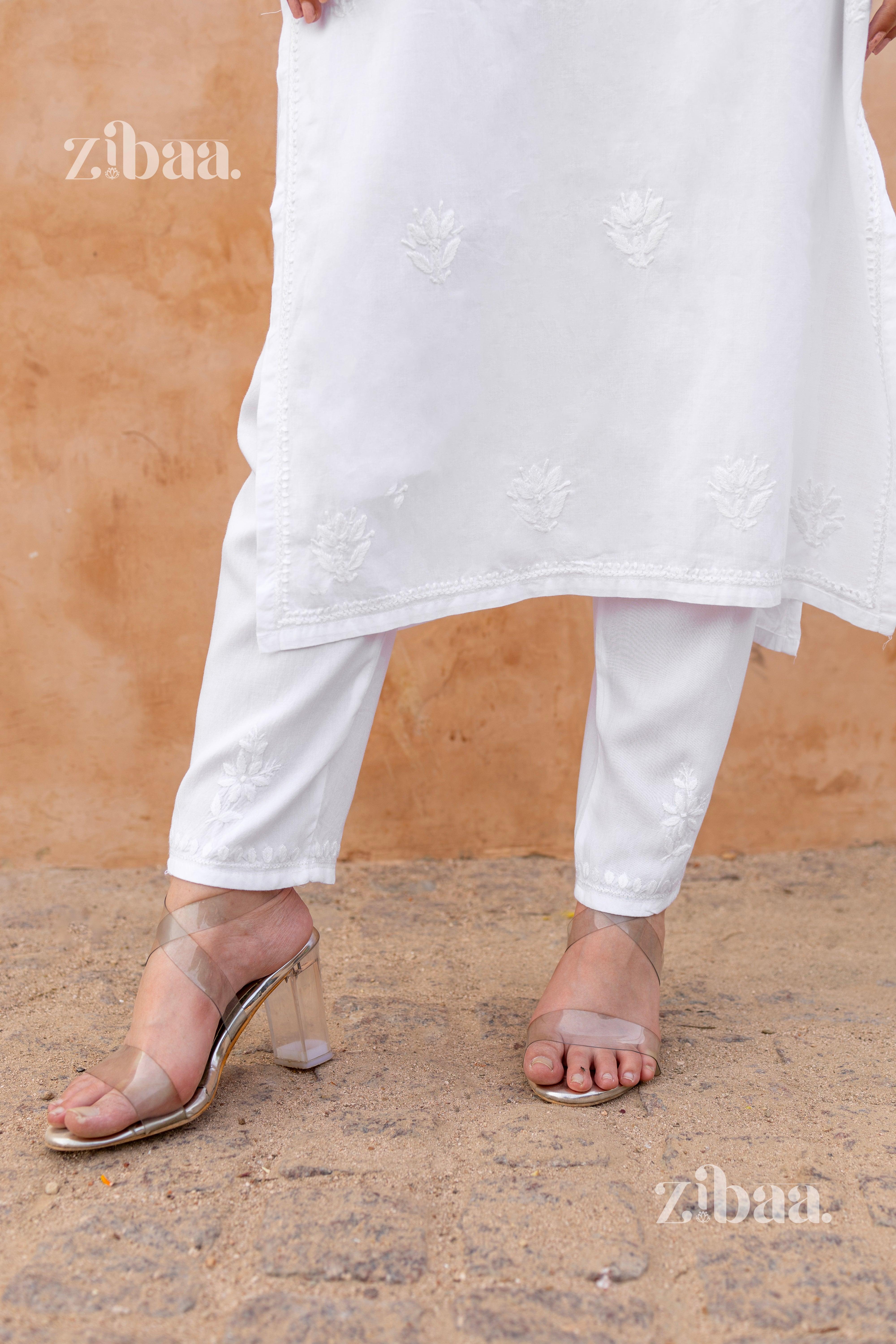 Close-up of white Chikankari palazzo paired with a matching embroidered kurti and transparent block-heeled sandals, styled elegantly.