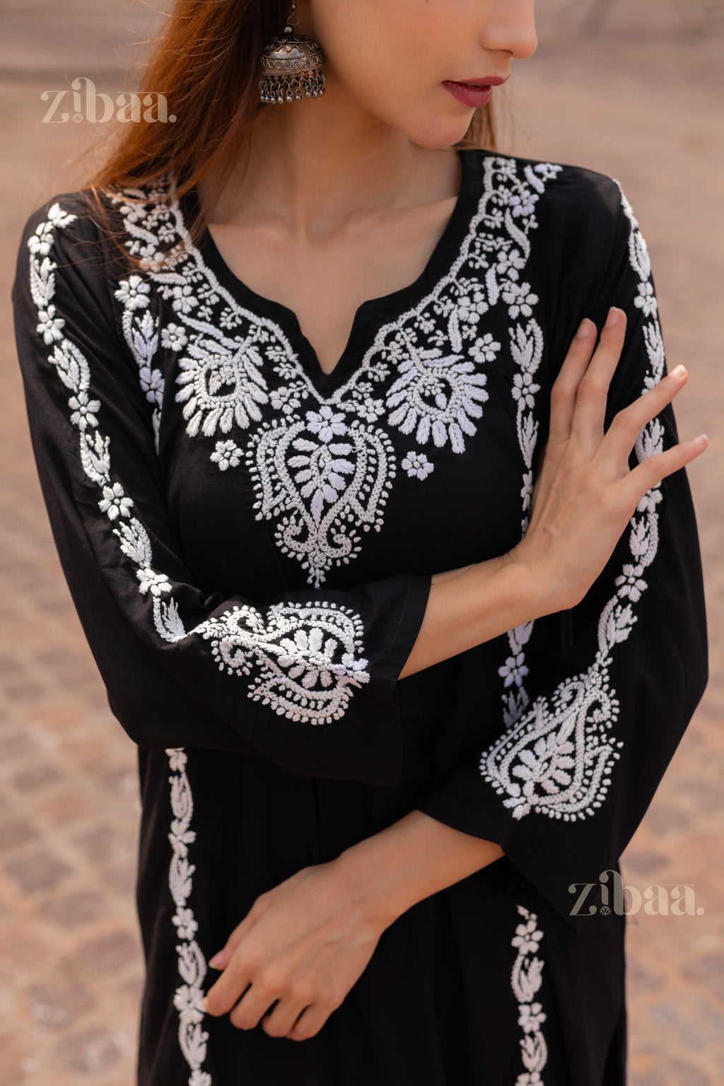 Model wearing a Black Chikankari Kurti with white embroidery, posing in front of a historic monument, showcasing its beauty.